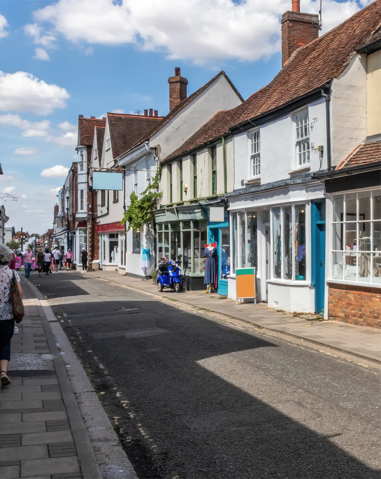 A quiet high street scene with a row of old buildings and shops